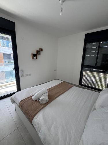 a bedroom with a large bed with two towels on it at Boutique Nesher in Nesher
