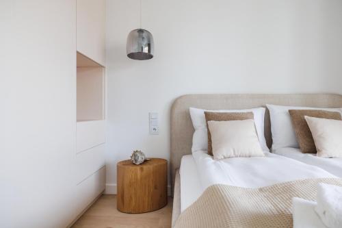 a bedroom with two beds and a wooden table at Rezydencja Merwede Aparthotel - My Rest in Gdańsk