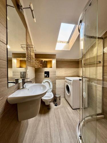 a bathroom with a sink toilet and a washing machine at Къща за гости Роси in Pomorie
