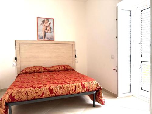 a bedroom with a bed with a red comforter at Casa di Mael in Maratea