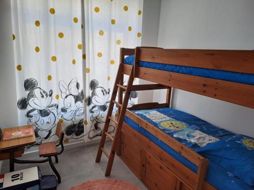 - une chambre avec des lits superposés et un rideau dans l'établissement La baraque bleriot beach, à Sangatte