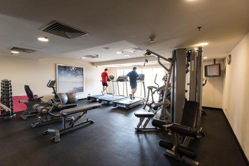 due persone in palestra con diversi tapis roulant di Minimal Resort Suites 3 Pax Sunway Pyramid a Petaling Jaya