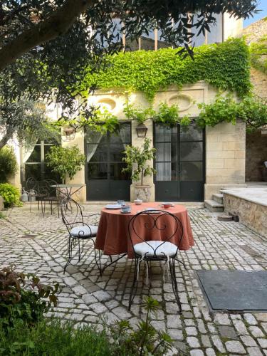 a table and chairs in front of a building at Le patio de Collias in Collias