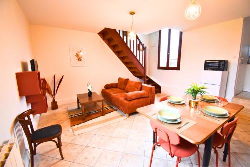 un salon avec une table et un canapé dans l'établissement Tour Pleyel - Duplex Lumineux, à Saint-Denis