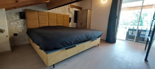 a large bed in a room with a large window at Gite Rive Charente Le Bateau in Bords
