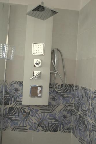 a bathroom with a shower with blue and white tiles at D&C House in Galatone