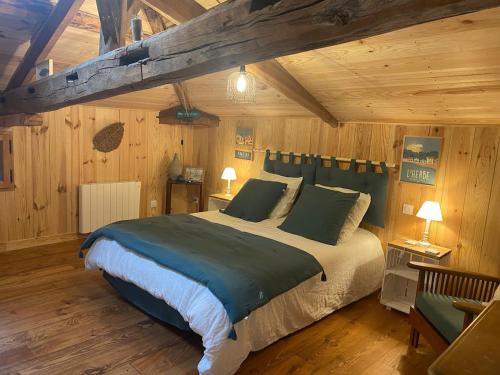 une chambre avec un grand lit dans une pièce aux murs en bois dans l'établissement Country home with pool and garage, à Cazalis