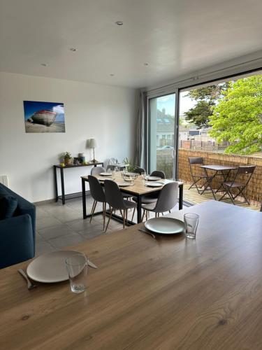 une salle à manger avec une table et des chaises et un salon dans l'établissement Barneville-Plage à 150m de la mer - grand hébergement cosy, à Barneville-Carteret
