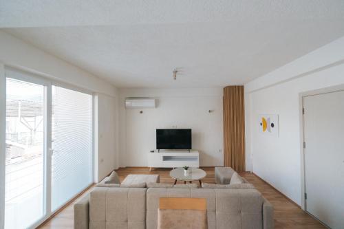 a living room with a couch and a tv at Albatross Apartments in Bitola