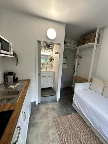 une petite chambre avec un lit et un lavabo dans l'établissement STUDIO proche commodité et gare . Centre ville, à Caen
