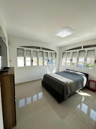 una camera da letto con un letto in una stanza con finestre di Villa la Nautilia a Cap d'Agde