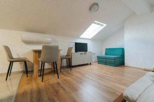 a living room with a table and chairs and a couch at Albatross Apartments in Bitola