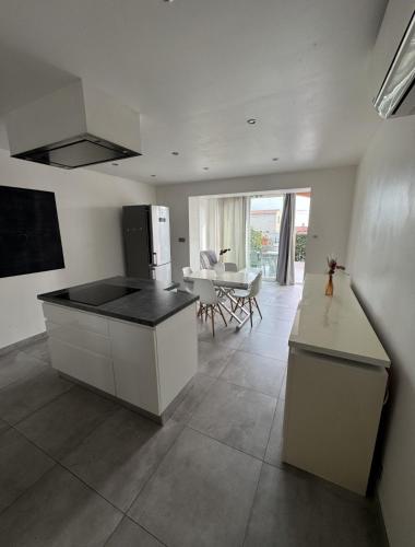 une cuisine avec un comptoir et une table à l'intérieur dans l'établissement Petit Nid Pieds dans l'eau, à Sausset-les-Pins