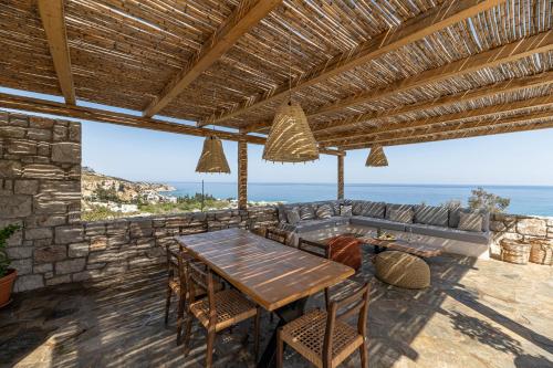 an outdoor patio with a wooden table and a couch at Villa Stavros in Archangelos