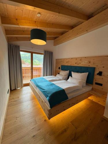 a bedroom with a large bed with a wooden ceiling at Ferienwohnungen Göhl in Bad Hindelang