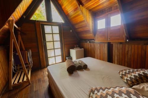 a bedroom with a large bed in a wooden cabin at Chalé da Árvore Cotijuba COP 30 in Belém