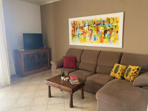 a living room with a couch and a table at Tropical Casa Castanha in Santa Maria