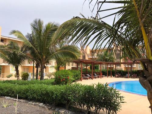 a resort with a swimming pool and palm trees at Tropical Casa Castanha in Santa Maria