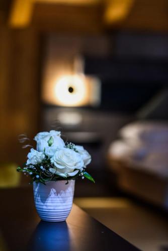 a white vase filled with white flowers on a table at Welcome to Select Baile Figa in Agrişu de Sus