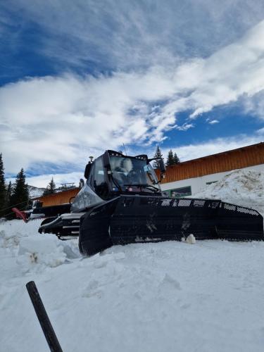 a bulldozer in the snow in front of a building at Haus Andrea in Planneralm