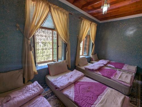 a room with three beds and a window at Gite D'etape Ait Ali Nito Assounfou in Megdaz