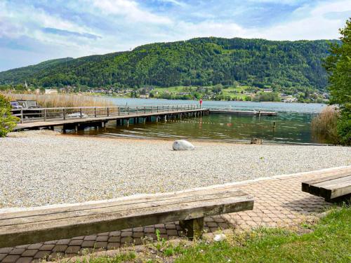 a bridge over a body of water with two benches at RIOpartment Ossiacher See in Bodensdorf