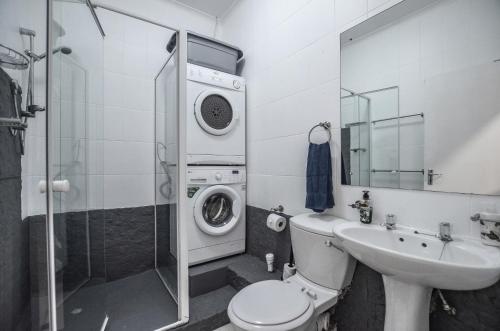 y baño con lavamanos y lavadora. en 55 Villa Fontana, en Yzerfontein