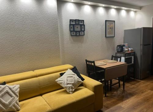 un salon avec un canapé jaune et une table dans l'établissement Studio au front de mer , Plage de Calais, à Calais