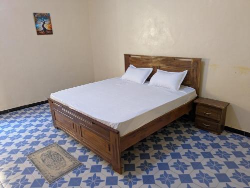 a bed with two pillows on it in a room at a true haven of peace in Darou Rhamane