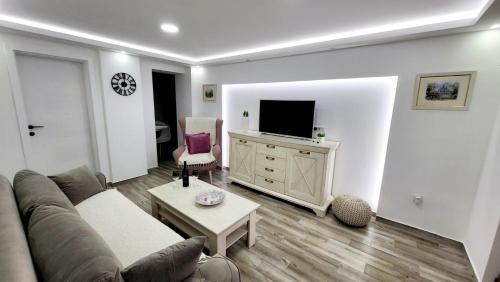 a living room with a couch and a tv at Nomad Montenegro in Topla