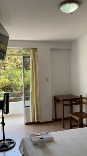 a bedroom with a bed and a window and a table at Hospedaje Rio Hotels Mancora in Máncora