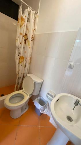 a bathroom with a toilet and a sink at Hospedaje Rio Hotels Mancora in Máncora