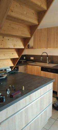 une cuisine avec un comptoir noir et des placards en bois dans l'établissement Spacious lake house, à Bilieu