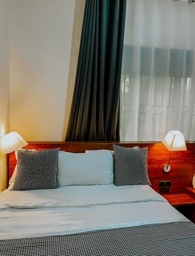 a bedroom with a bed with two lamps and a window at Casa Residence Mbarara in Mbarara