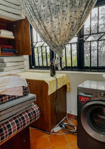 a laundry room with a washing machine and a window at Casa Residence Mbarara in Mbarara