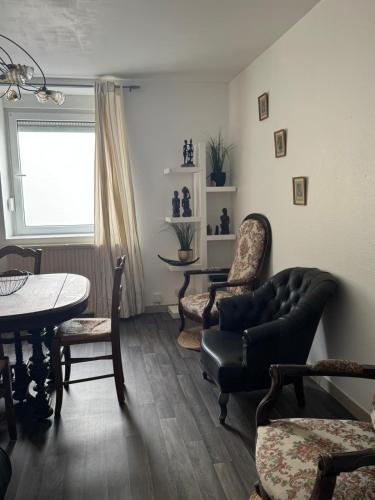 a living room with a couch and chairs and a table at 200 m centre ville maison mitoyenne avec place de parking gratuite in Épinal