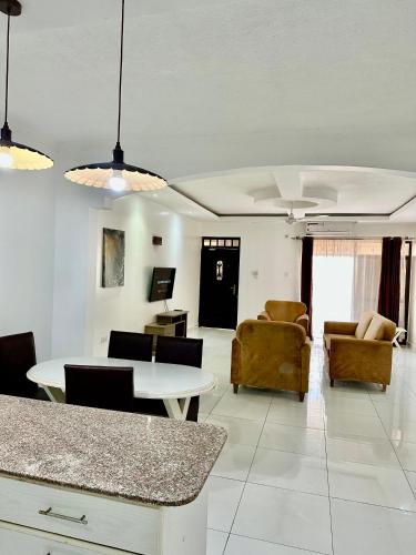 a living room with a table and chairs at Clalem Condos Diani Beach in Diani Beach