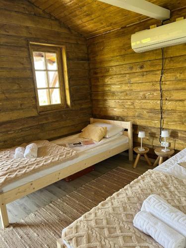 una camera con un letto in una baita di tronchi di Casuta 5 a Ciocănari