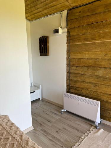 una stanza con una grande parete di legno con una stufa di Casuta 5 a Ciocănari