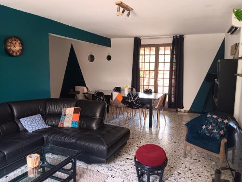 un salon avec un canapé en cuir noir et une table dans l'établissement El terret, à Sigean