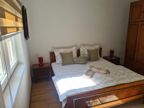 a bedroom with a bed with pillows and a window at Apartmani Podvisoki in Visoko