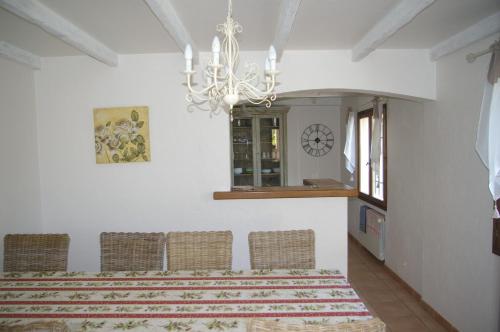 une salle à manger avec des chaises et un lustre dans l'établissement Villa les figuiers, à Lorgues