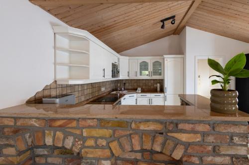 Una cocina grande con encimera de piedra y pared de ladrillo. en Bungalow zum Wohlfühlen, en Oranienburg