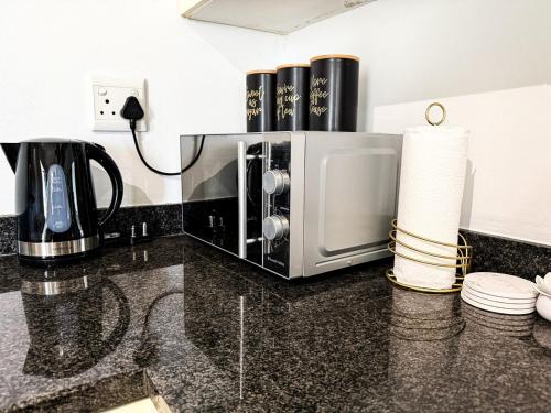 Un microondas colocado encima de una encimera de cocina. en Mayvlei Luxury CBD apartment, en Windhoek