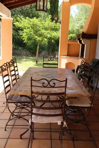 une table et des chaises en bois sur une terrasse dans l'établissement Villa les figuiers, à Lorgues