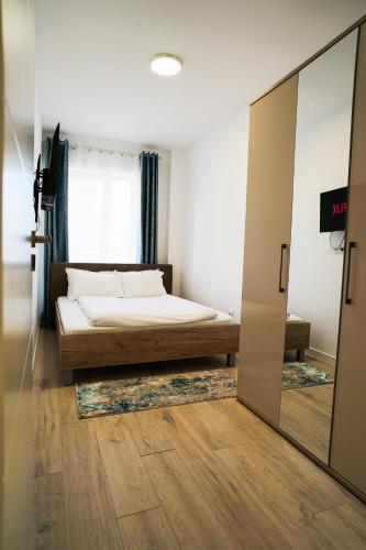 a bedroom with a bed and a mirror at Mirandis Apartments - Modern Stays with Free Parking near Coresi Mall in Braşov