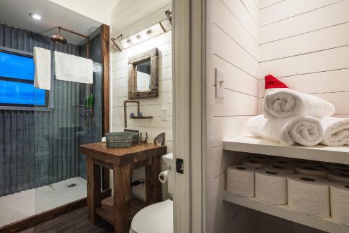 a bathroom with a toilet and a shower and towels at The Joshua Tree Outpost + Hot Tub in Hidden River