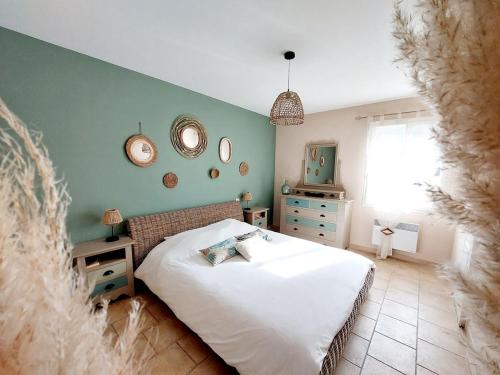 une chambre avec un lit blanc et un mur vert dans l'établissement En Provence, Luberon, villa avec piscine à Maubec, à Maubec