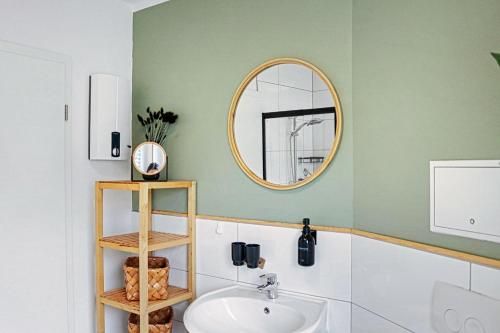 a bathroom with a sink and a mirror at Lunaria Living I VW Tor 17 - Gemütlich - Home Office - Zentral - Parkplatz in Wolfsburg