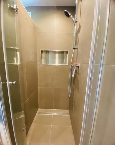 a shower with a glass door in a bathroom at Morning Glory Huisje Salvia in Beekbergen